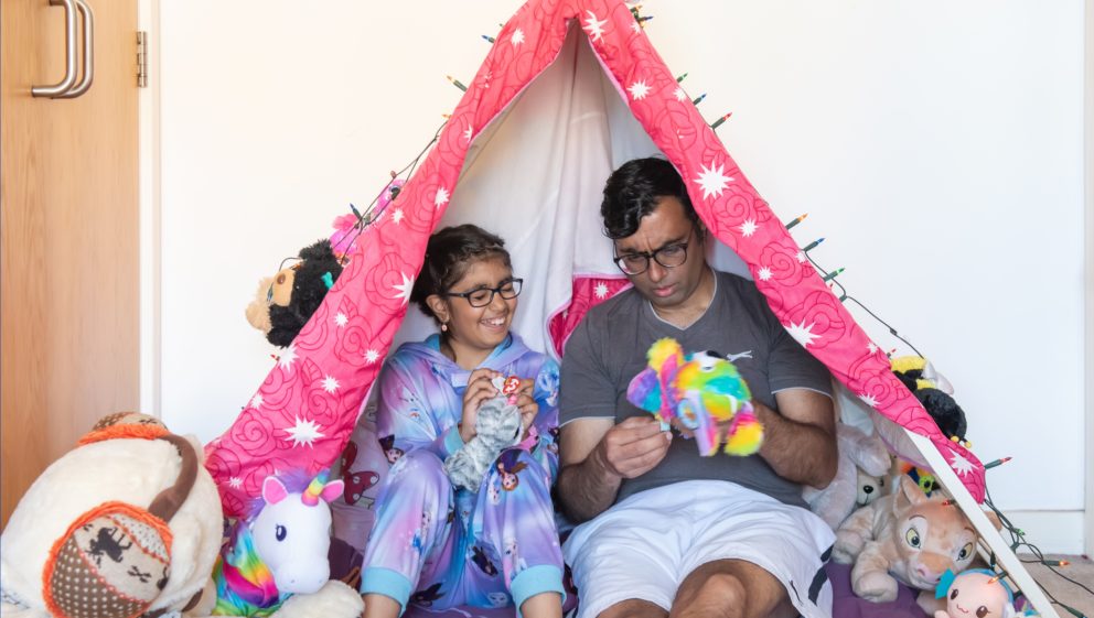 Vikas' single dad story - Vikas and his daughter play with toys in a tent